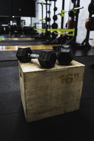 Close-up of fitness supplements and workout gear arranged neatly on a wooden table.
