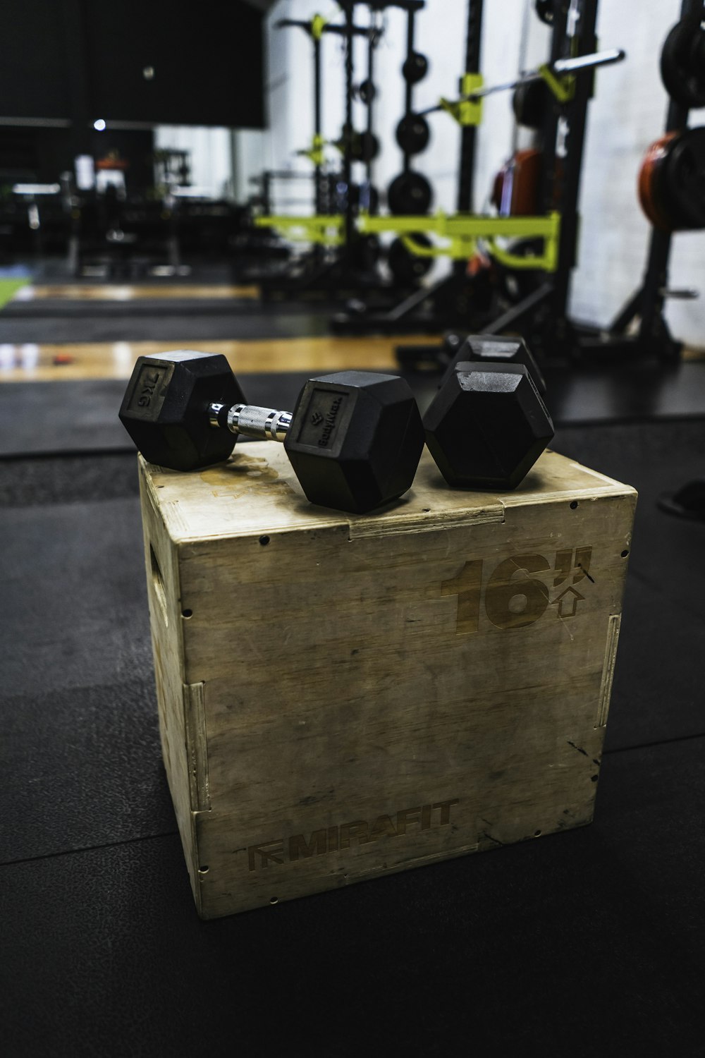 black and gray dumbbells on brown wooden crate