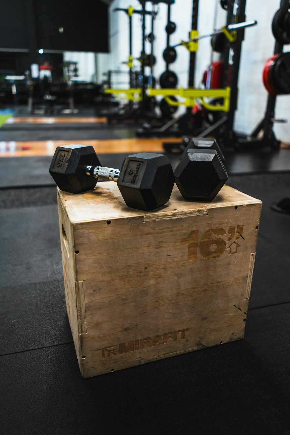 black and gray dumbbells on brown wooden crate