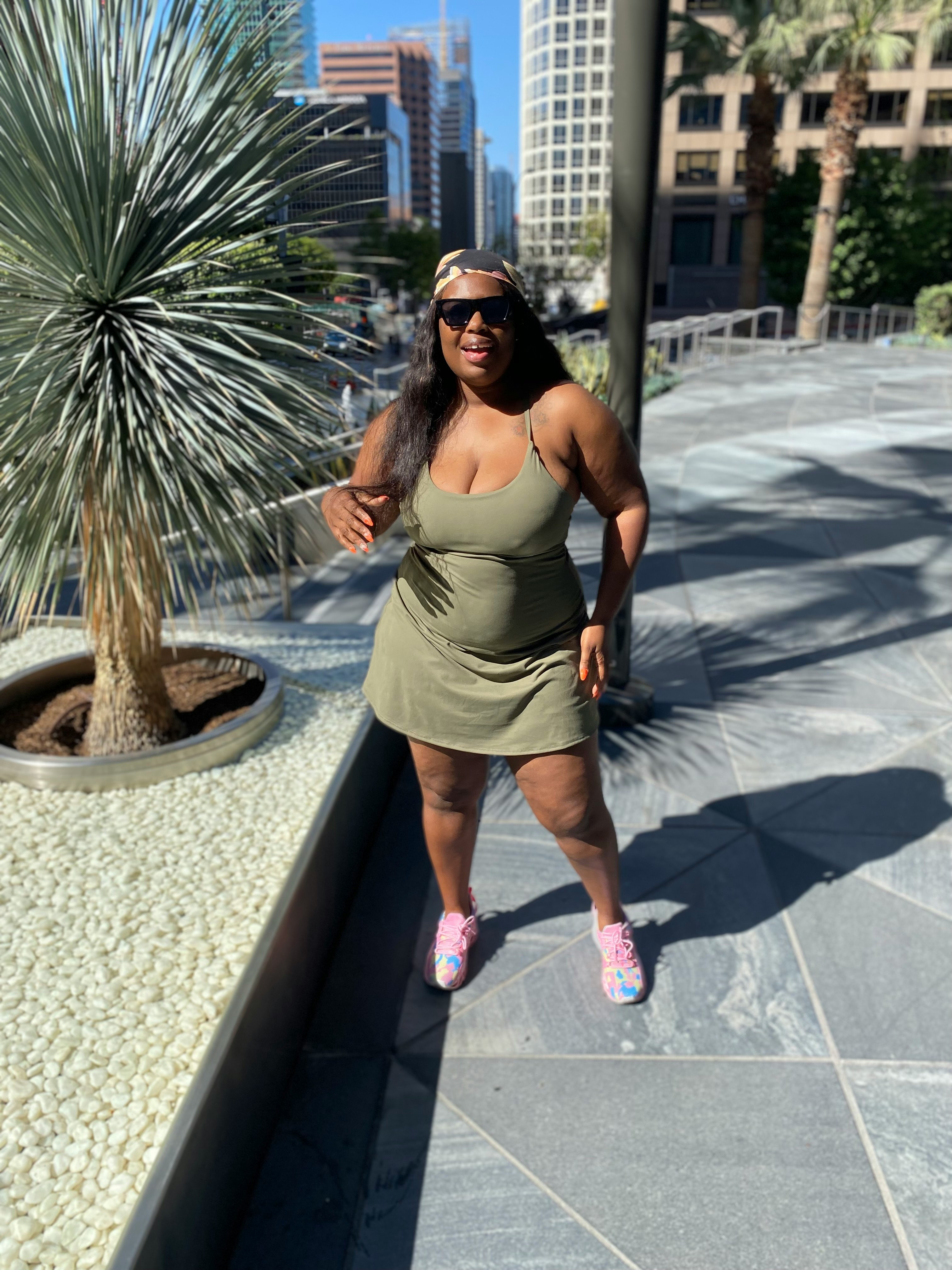 woman in gray spaghetti strap dress standing on gray concrete pathway during daytime