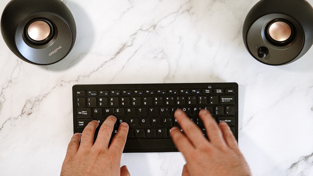 teclado de computadora negro sobre textil blanco