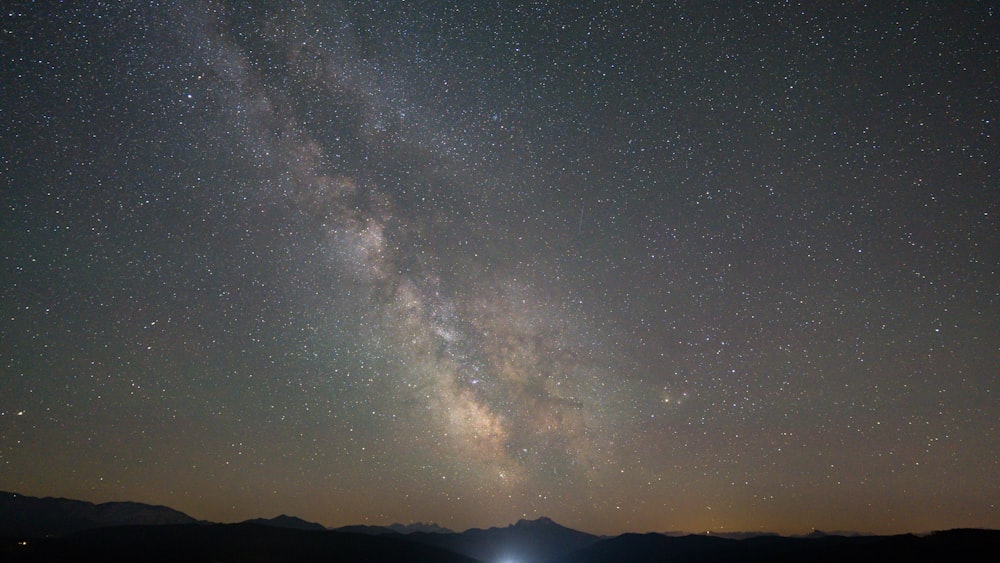 silhouette of mountain under starry night