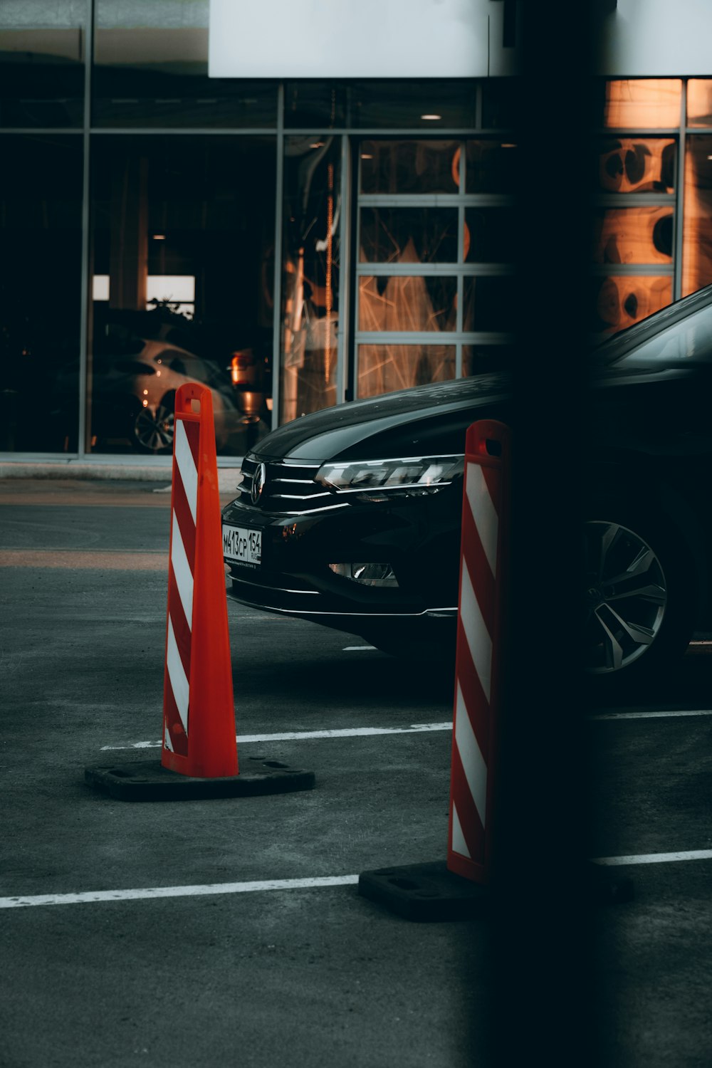 black car parked beside red and white striped pole