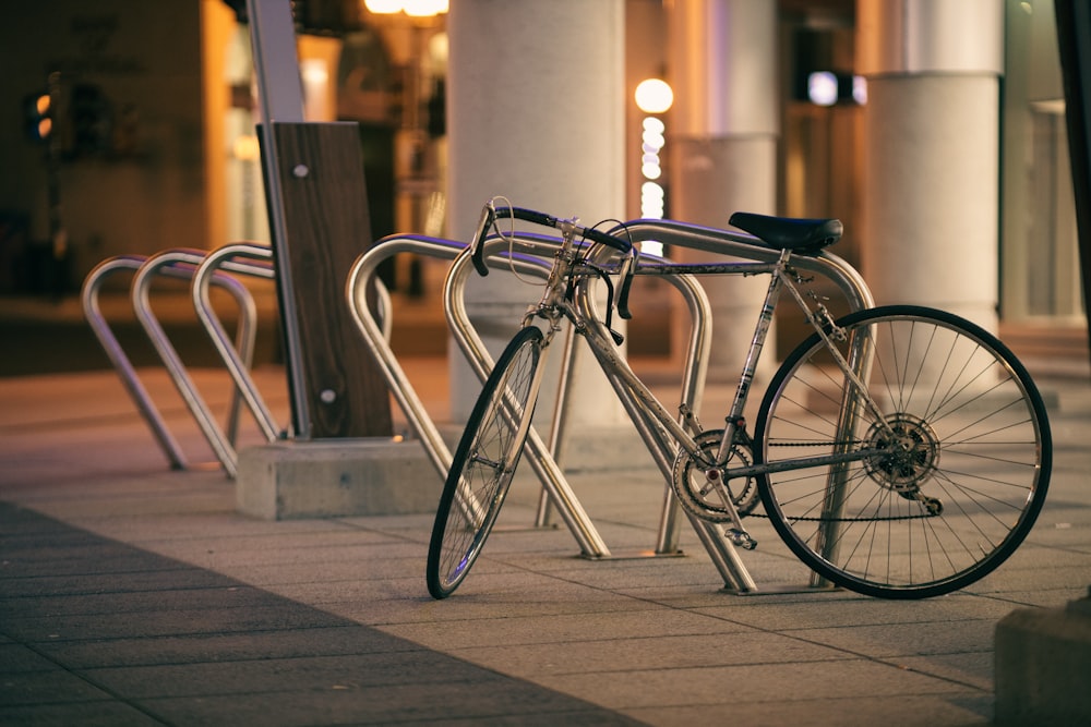 black city bike parked on sidewalk during daytime