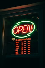 a neon sign that reads open business hours
