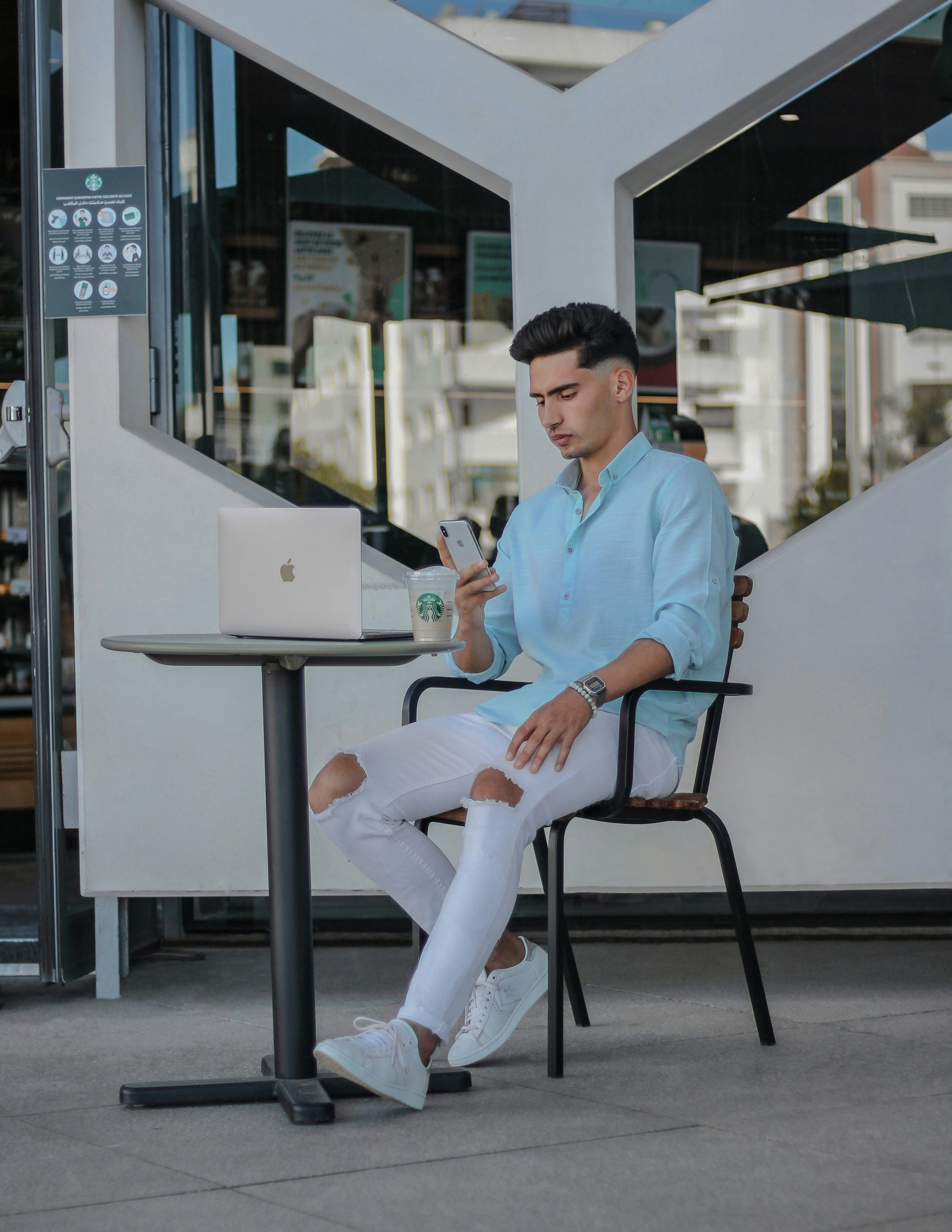 Mann im blauen Hemd sitzt auf Stuhl