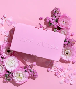 A delicate pink and white box adorned with cute kawaii characters and soft pastel ribbons.