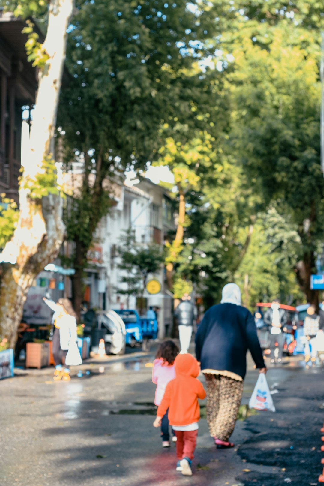 man in blue shirt and black pants walking on sidewalk during daytime