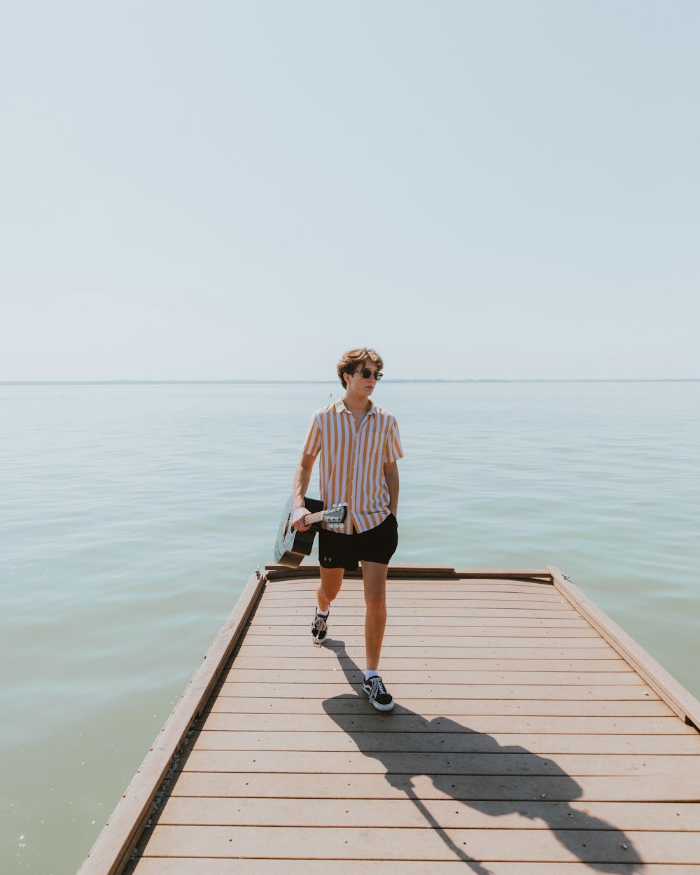 woman in black and white stripe shirt standing on dock during daytime