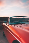 A bright red convertible with the top down on a sunny day.