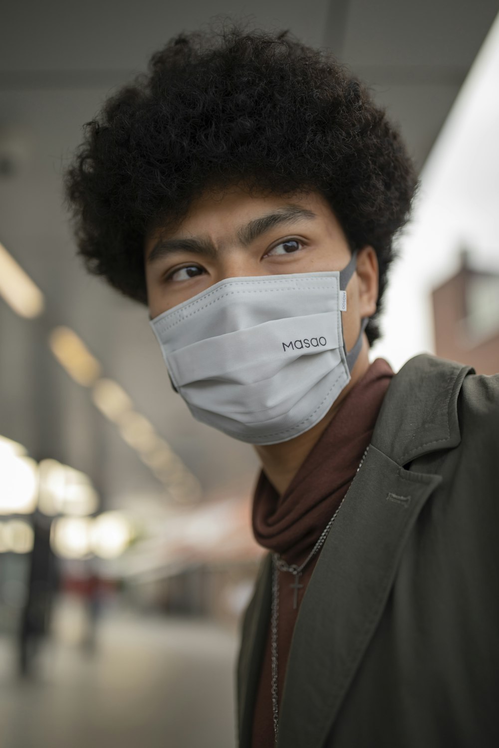 man in brown leather jacket with white face mask