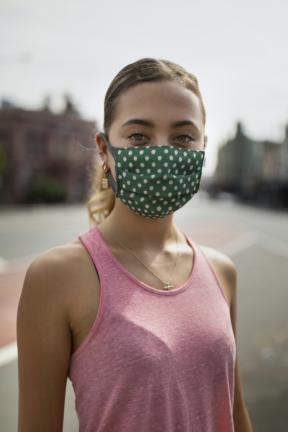 girl in pink tank top with green mask