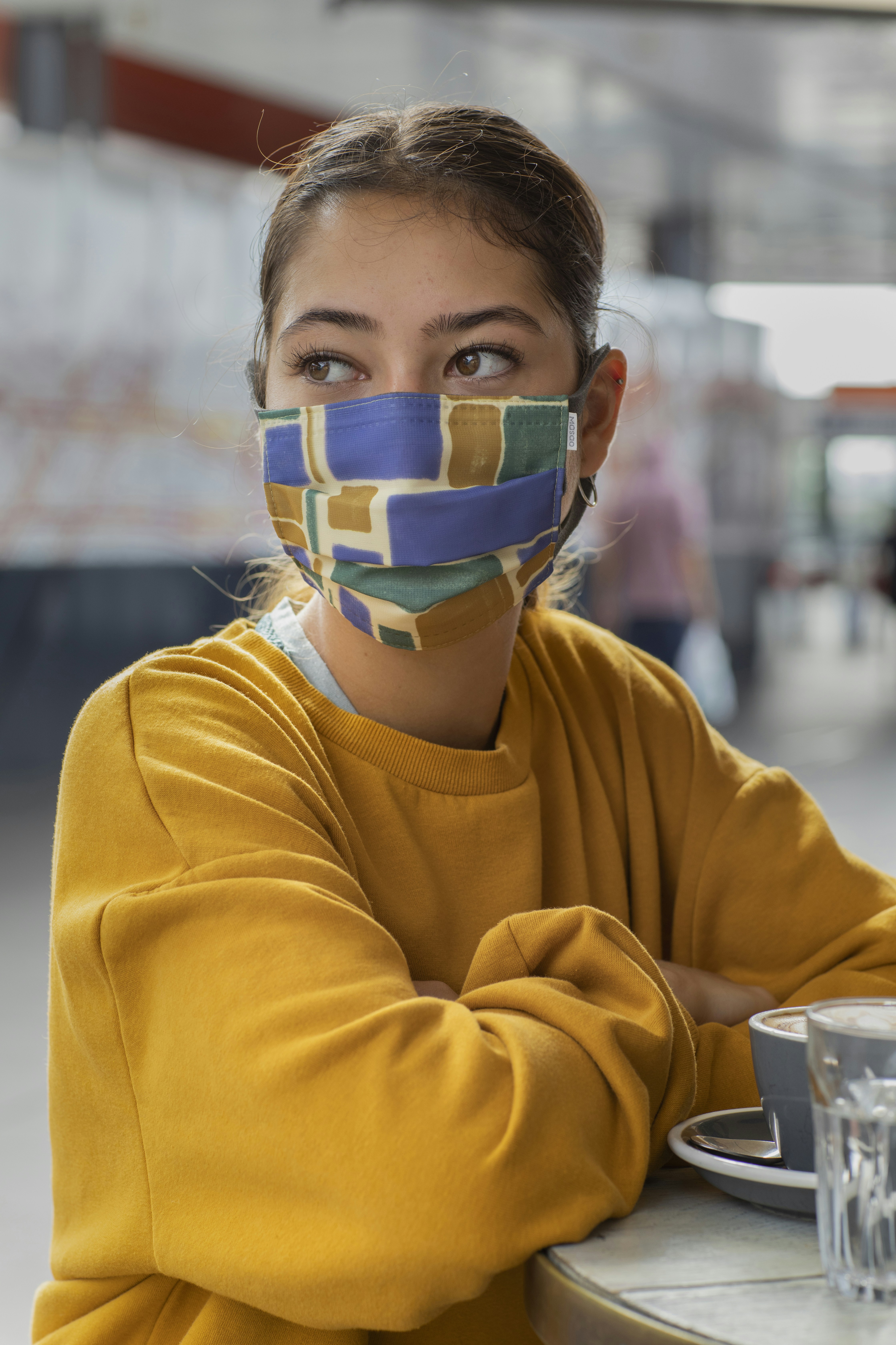 boy in yellow sweater with blue green and white mask