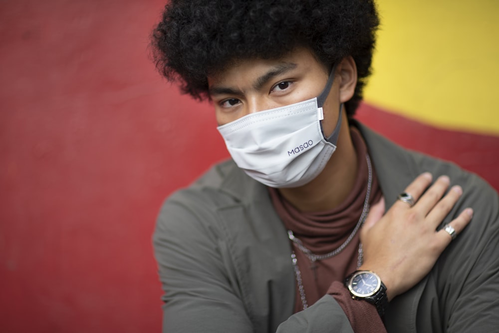 man in gray dress shirt wearing white face mask