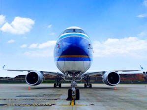 blue and white airplane under blue sky during daytime