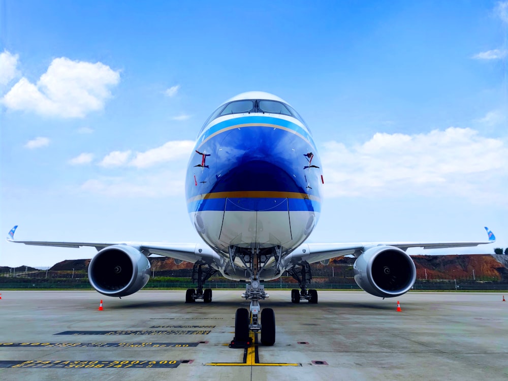 blue and white airplane under blue sky during daytime