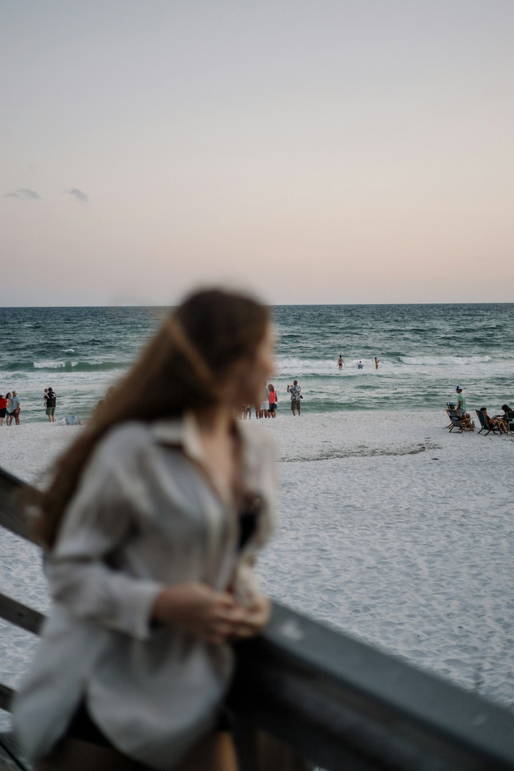 woman in white jacket standing on beach during daytime