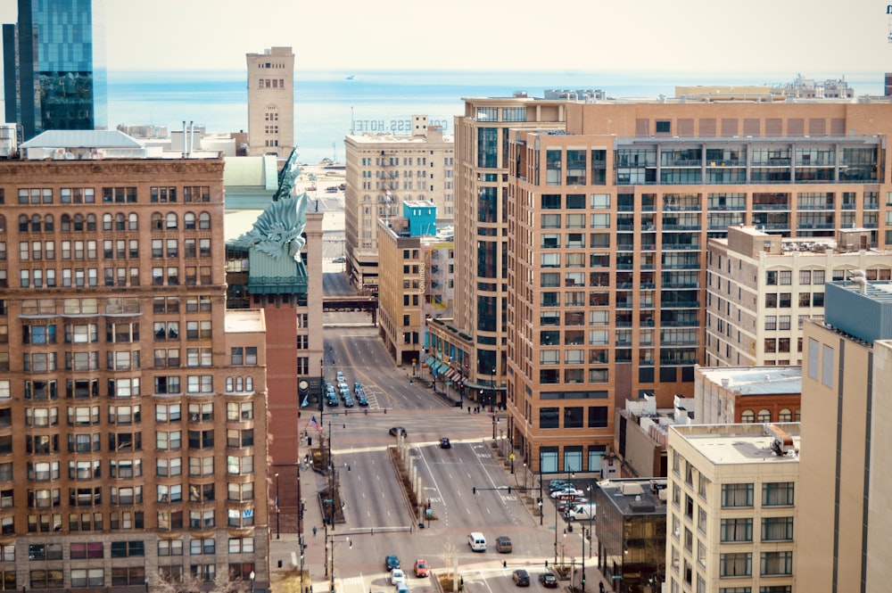 cars on road in between high rise buildings during daytime