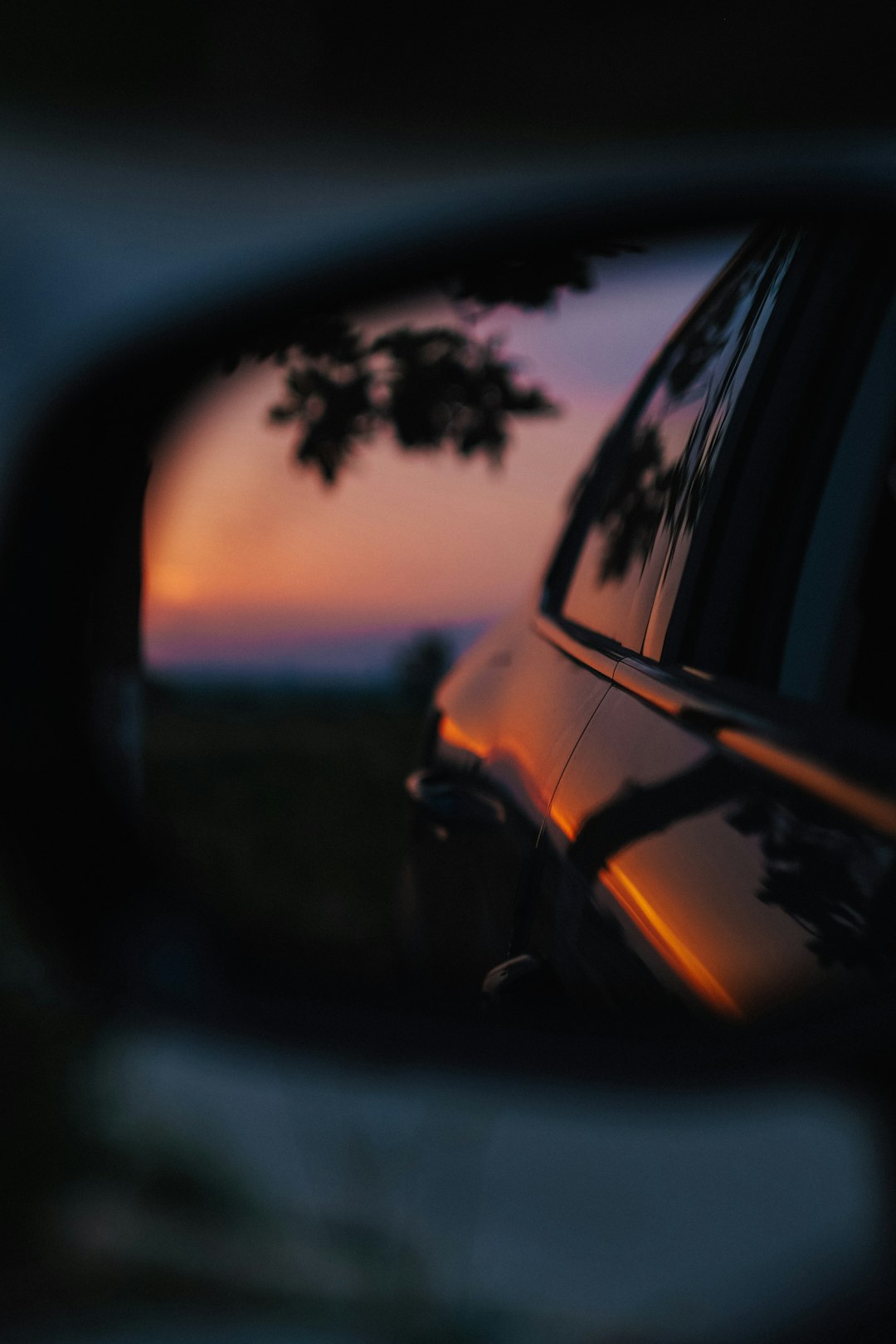 black car side mirror reflecting black car