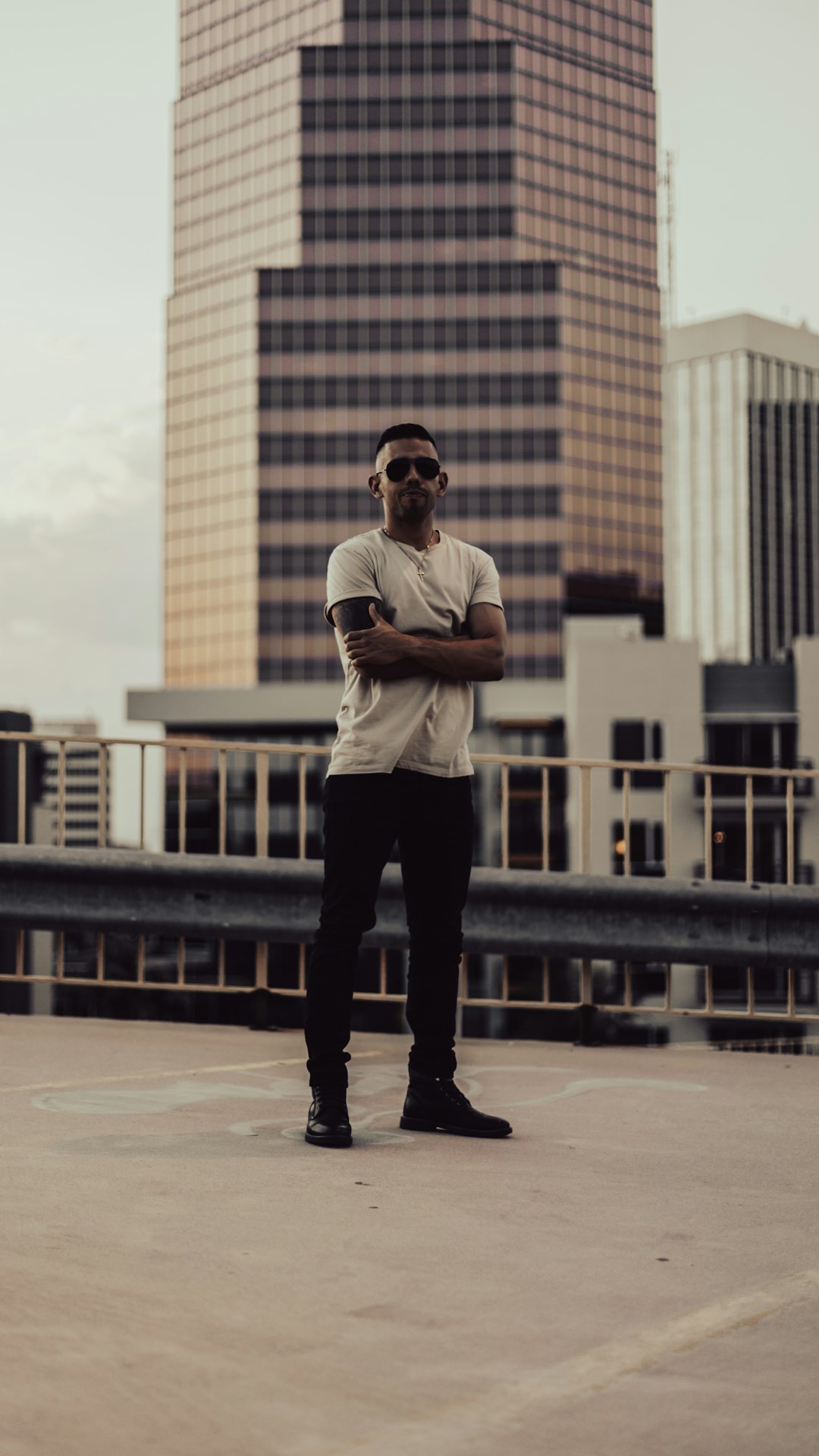 man in white shirt and black pants standing on brown concrete floor during daytime