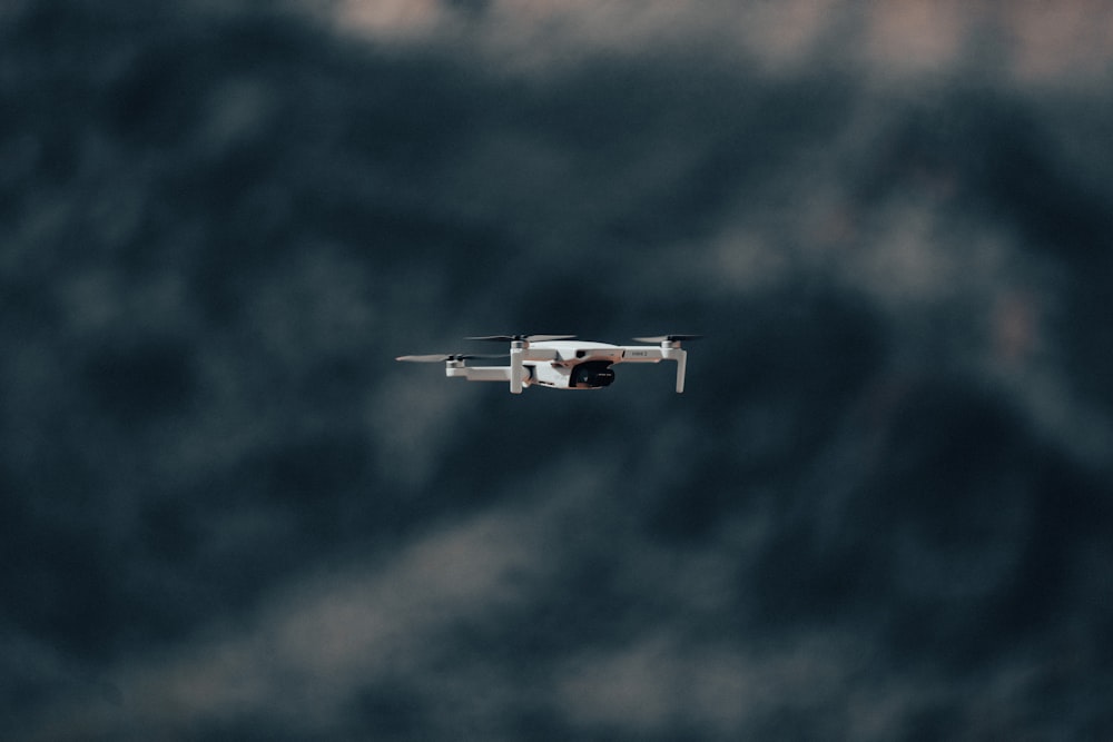 white and black airplane flying under blue sky