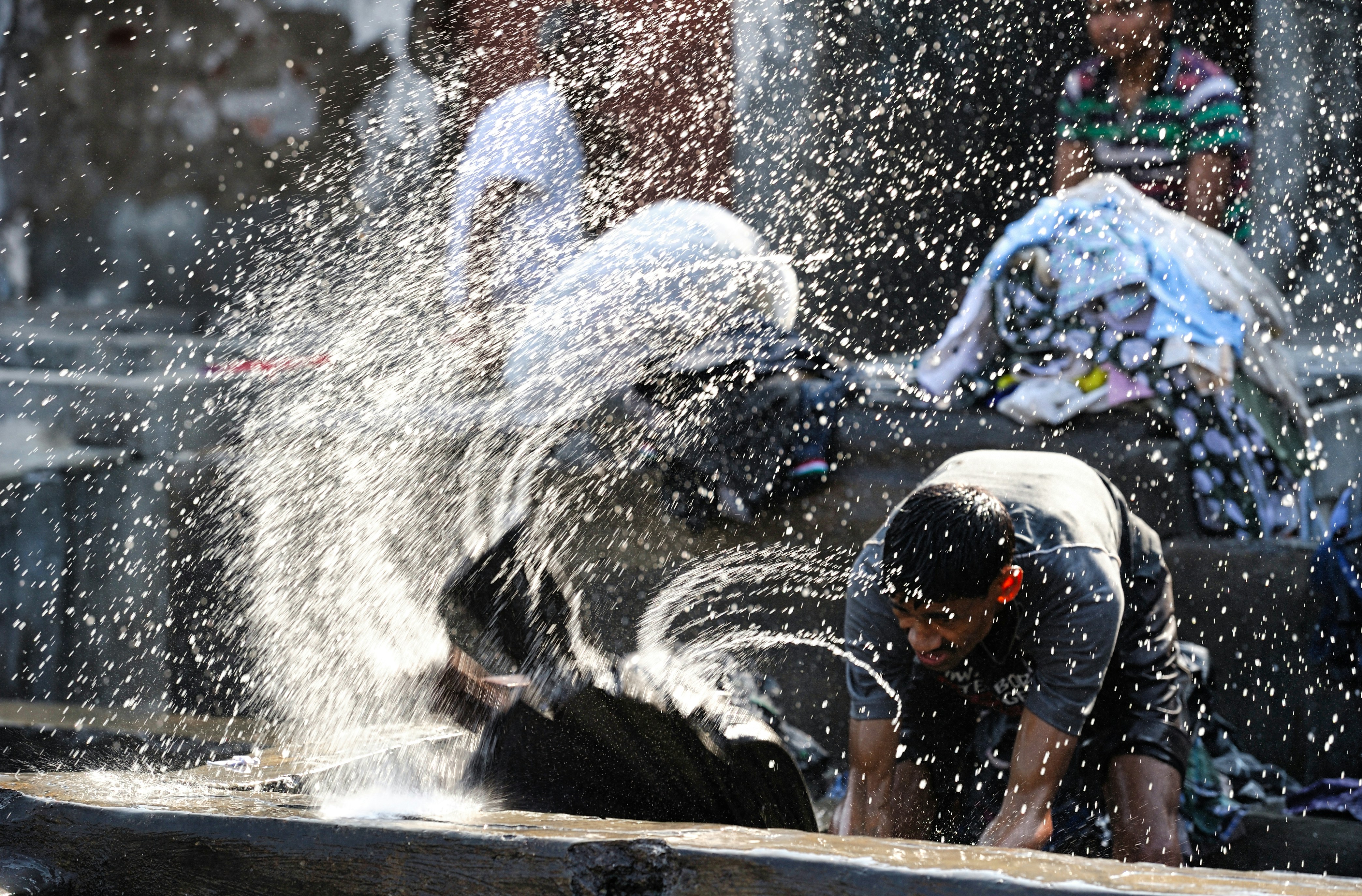 man in black wet suit playing with water