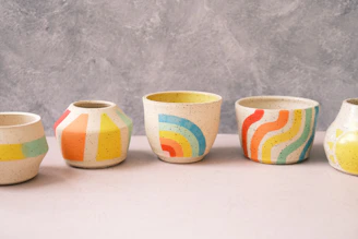 Close-up of colorful ceramic cups with unique hand-painted designs.