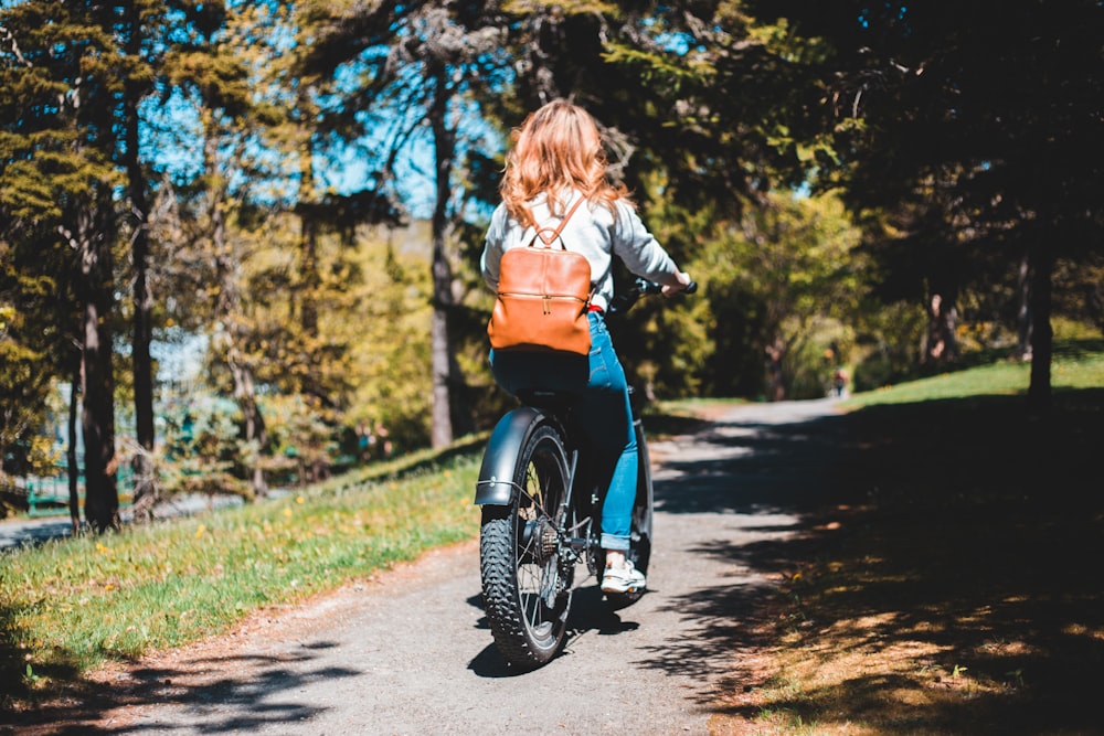 woman in black jacket riding on black motorcycle during daytime