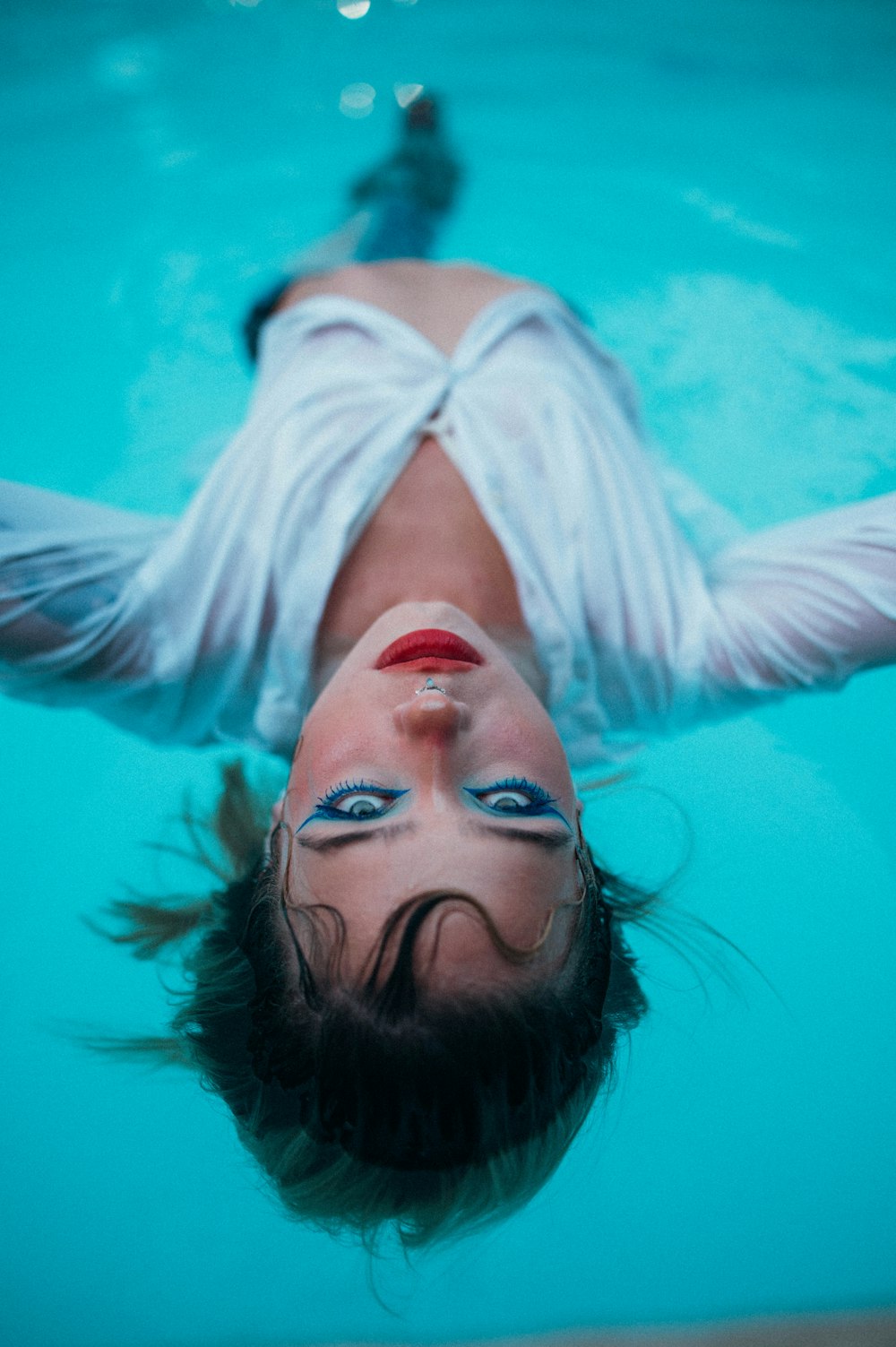 woman in white long sleeve shirt under water