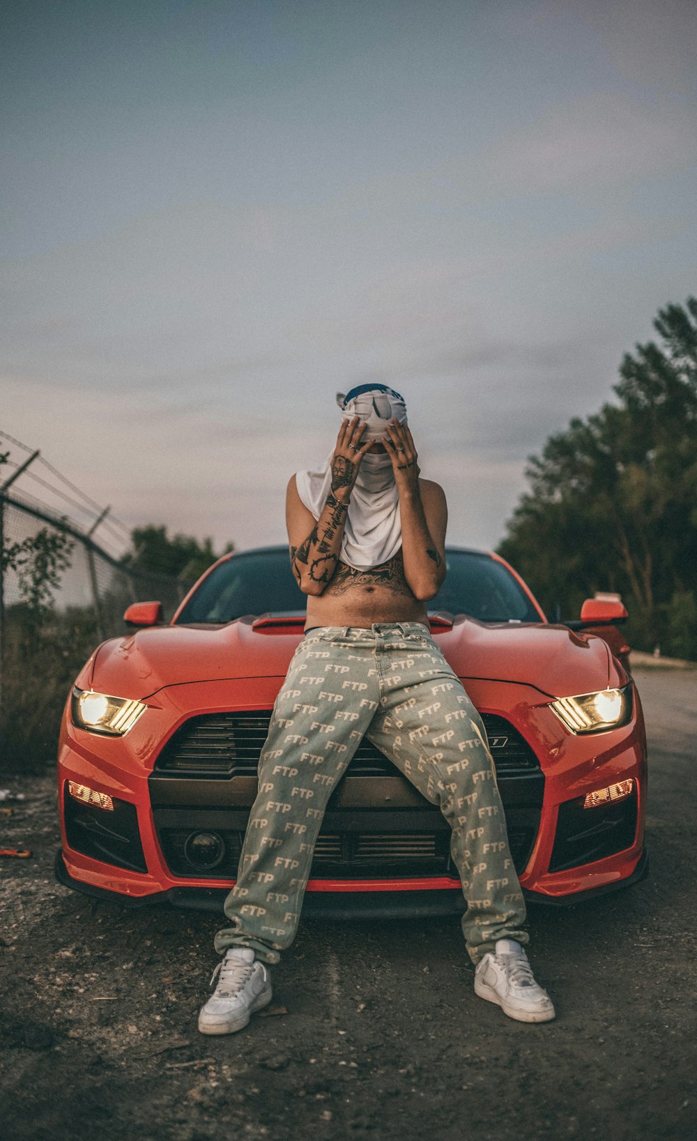 woman in brown and white long sleeve shirt sitting on red car