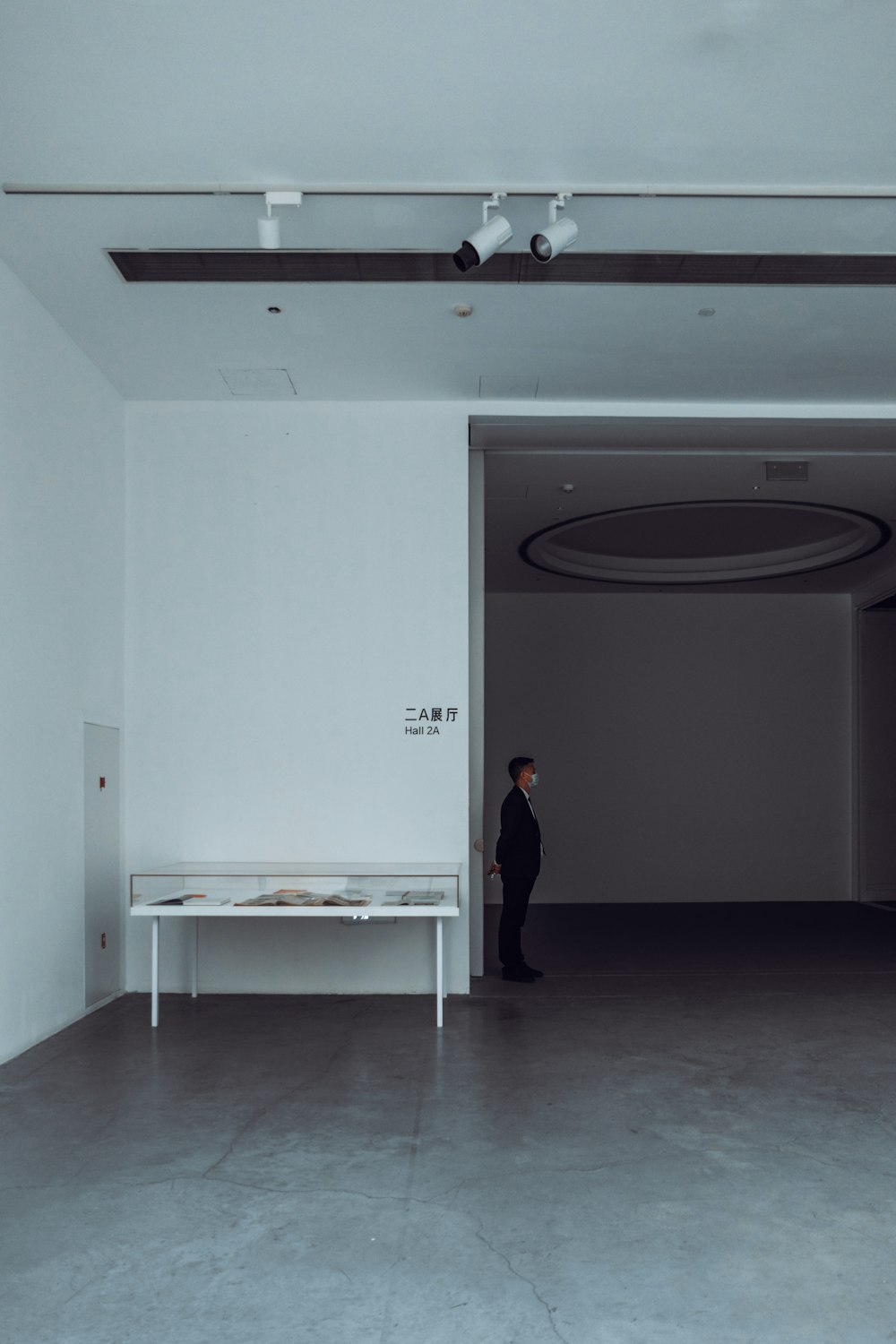 woman in black dress standing near white wall