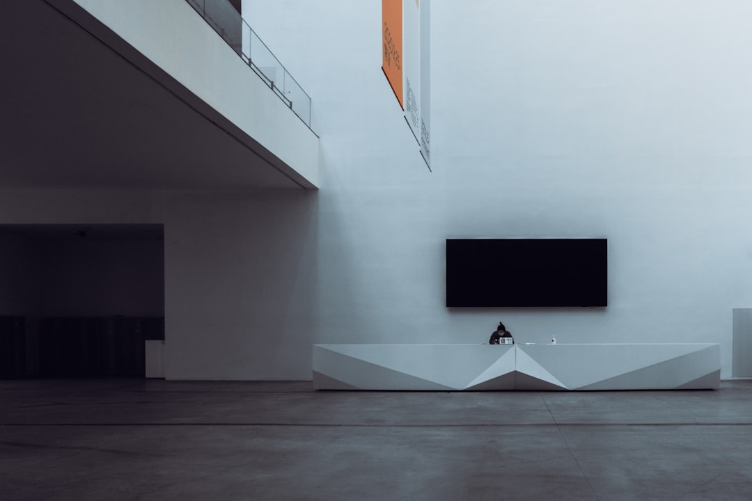 black flat screen tv mounted on white wall