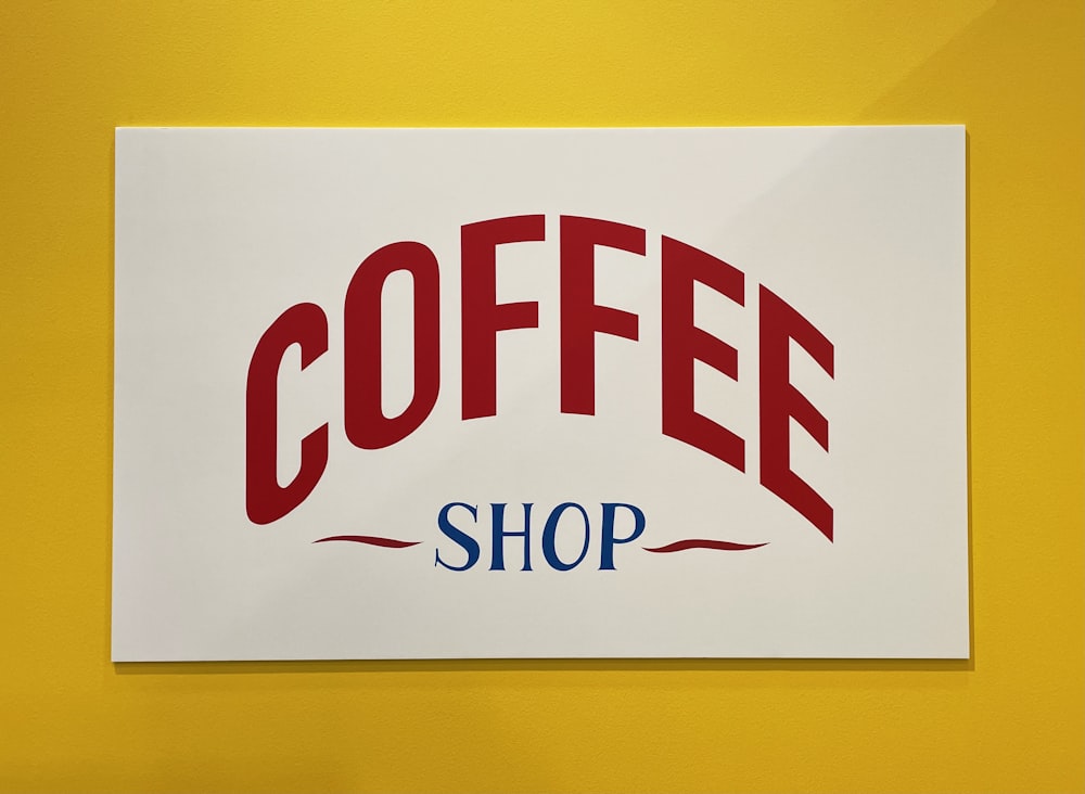 um sinal de café em uma parede amarela