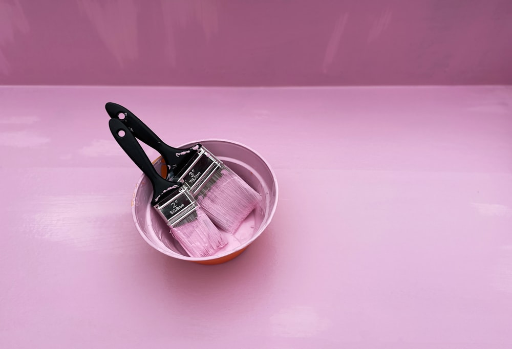 Edelstahl-Kochtopf auf rosa rundem Teller