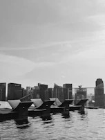 An infinity pool with panoramic views of a glittering skyline at dusk.