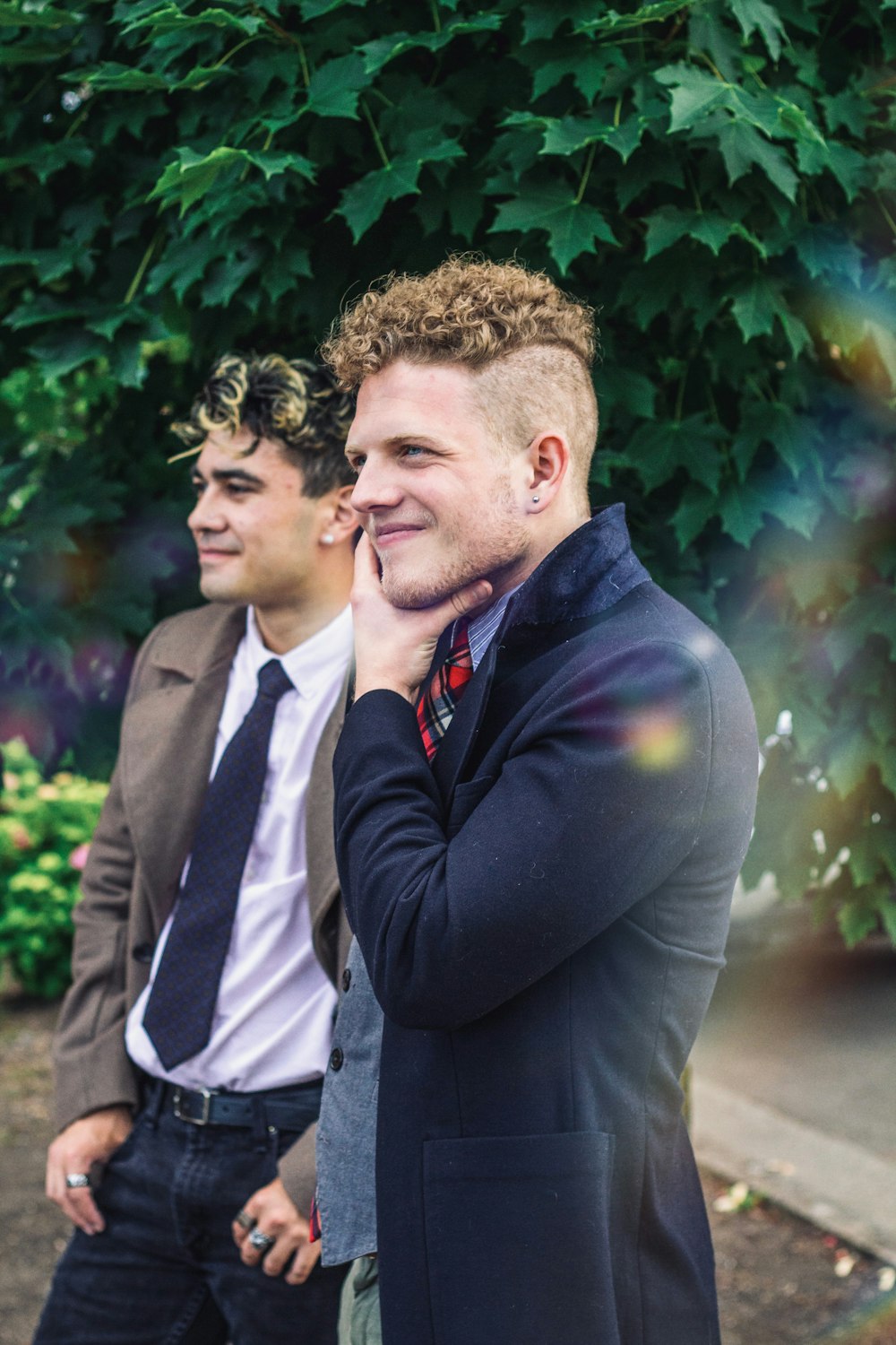 man in black suit jacket standing beside man in black suit