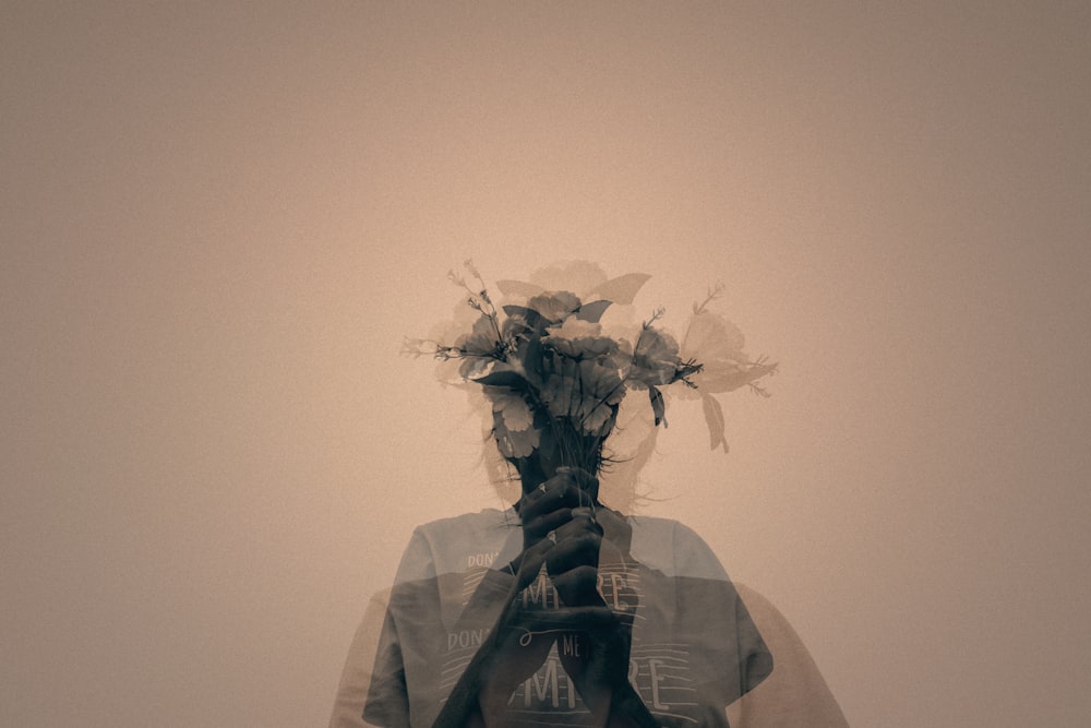 gray scale photo of man holding flower