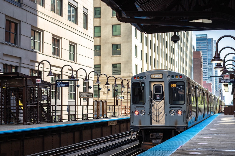 gray train on rail road near building during daytime