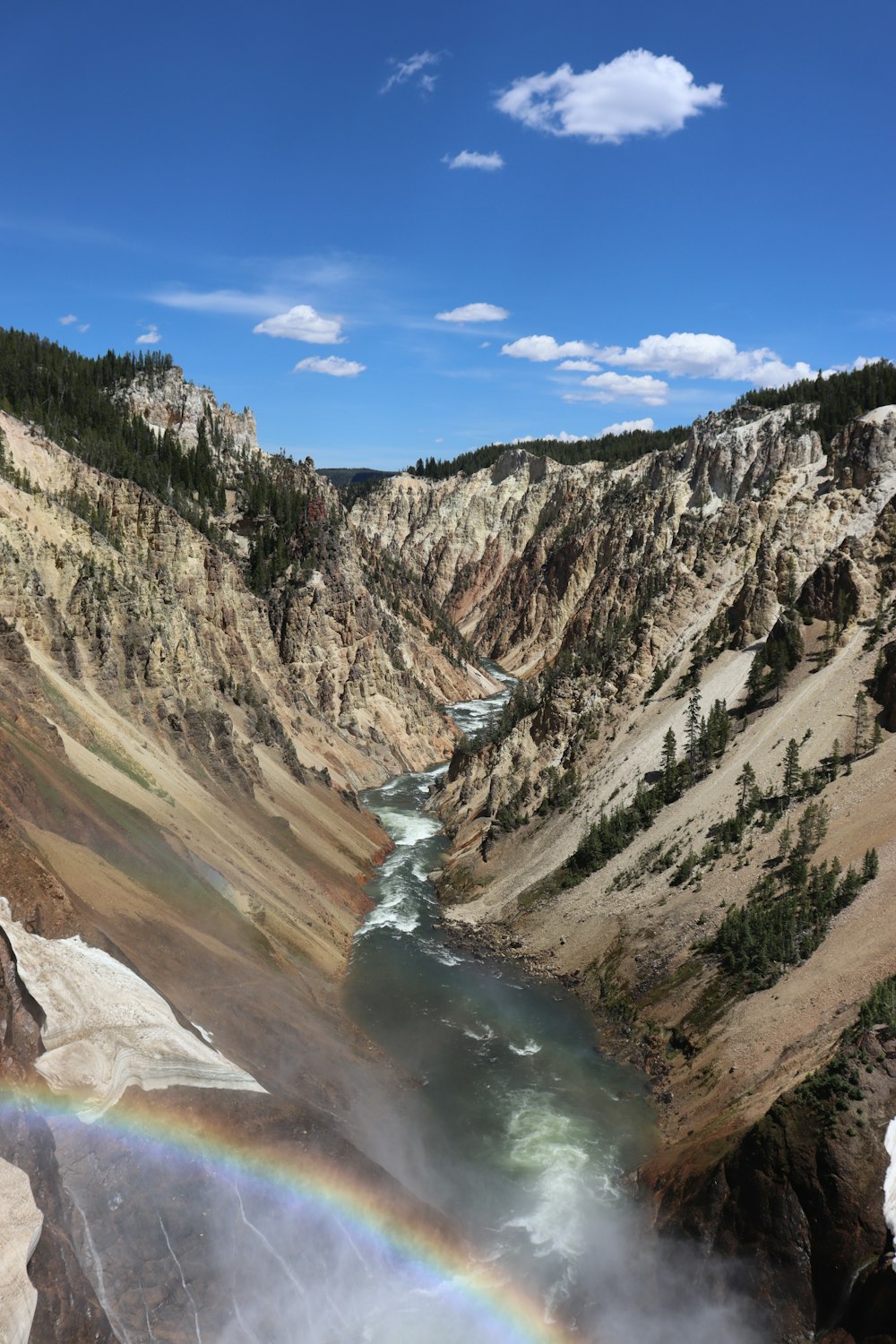 river between mountains under blue sky during daytime