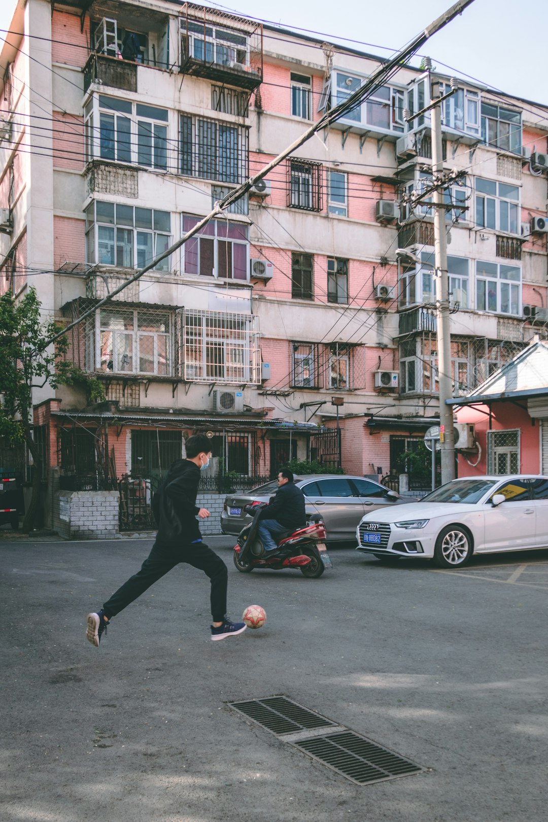 man in black jacket and black pants walking on sidewalk during daytime