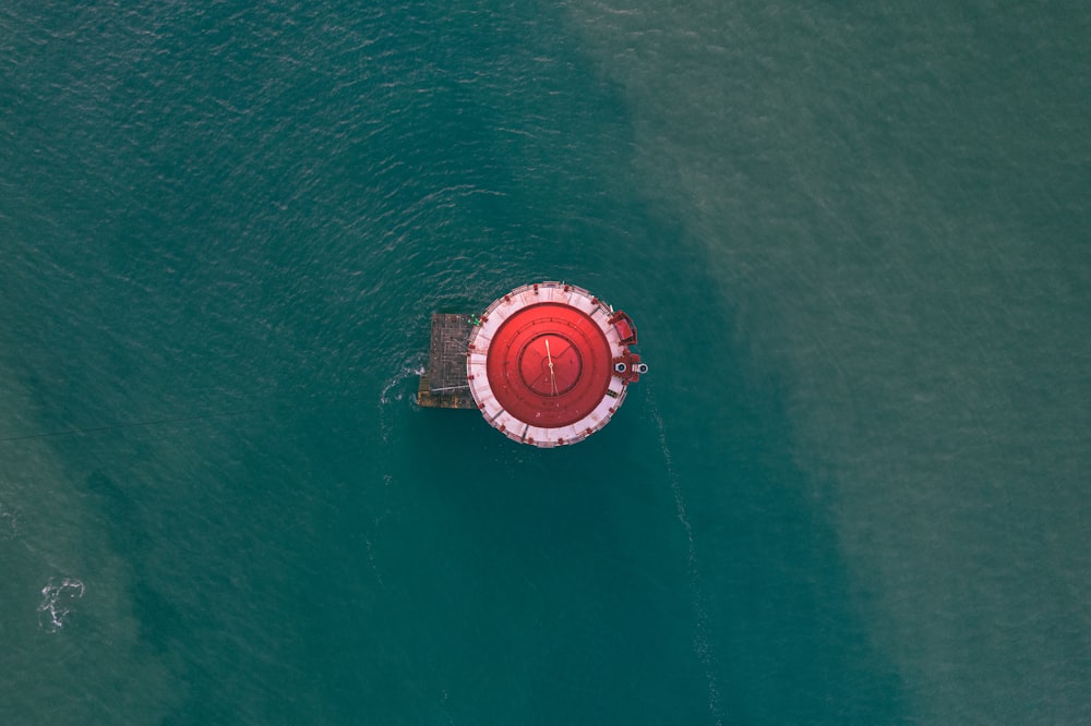 aerial view of red and white boat on green sea during daytime
