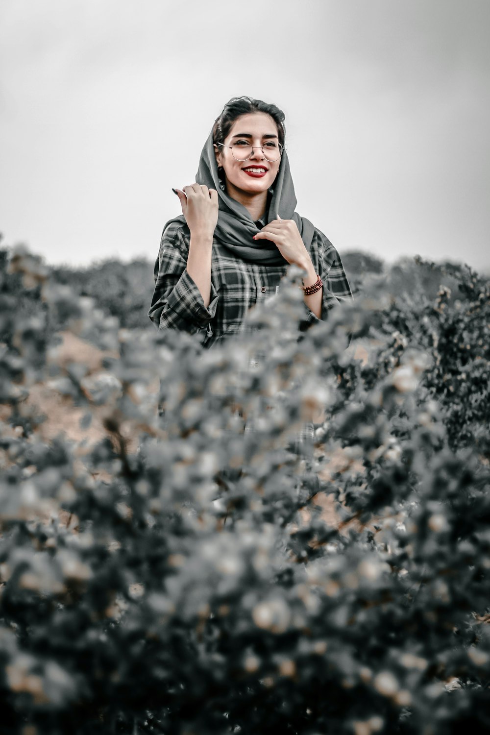 woman in black and white plaid long sleeve shirt standing on brown leaves during daytime