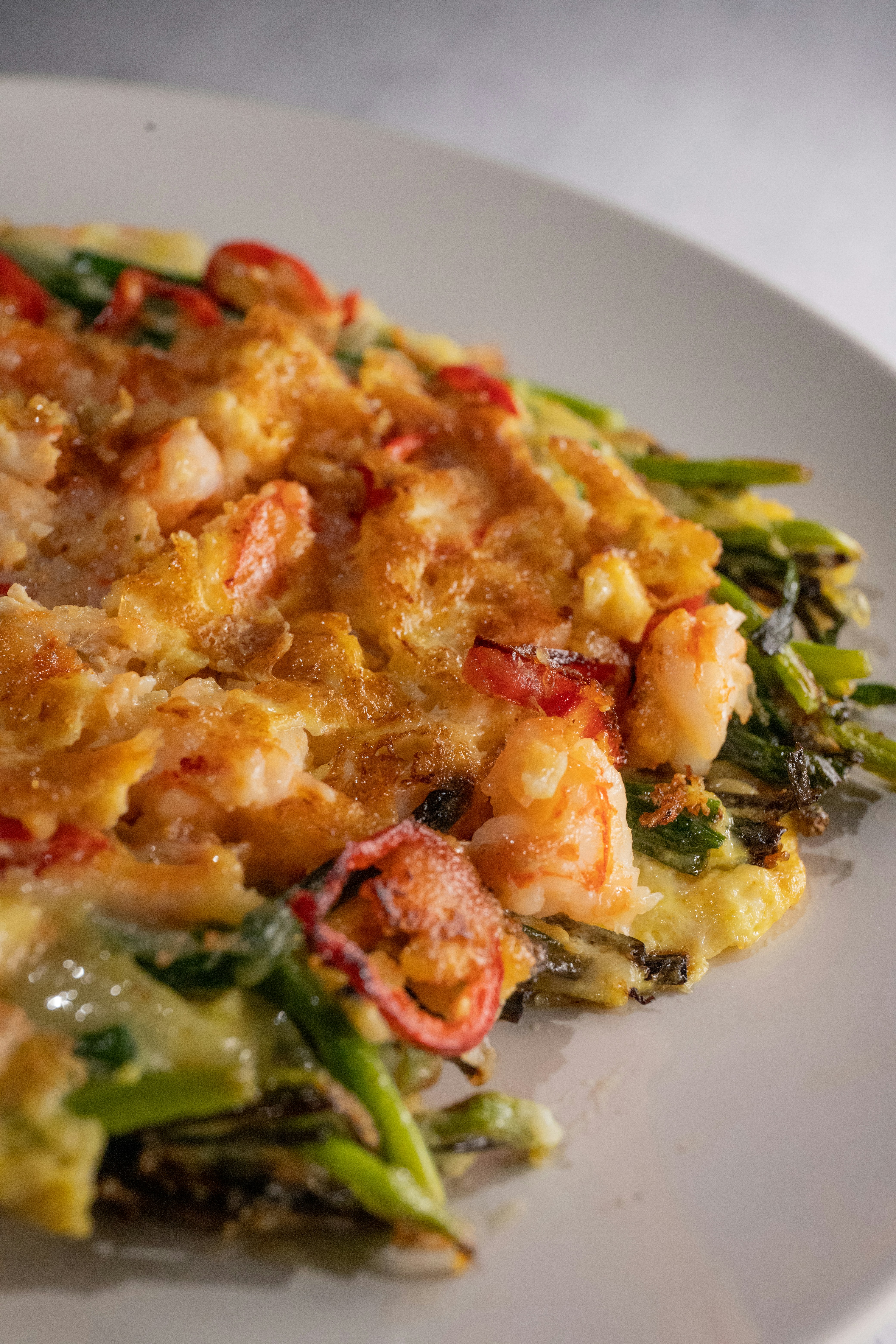 Crispy Korean green onion seafood pancake pajeon sliced into pieces with dipping sauce