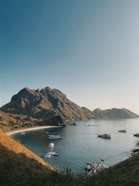 boat on water near mountain during daytime