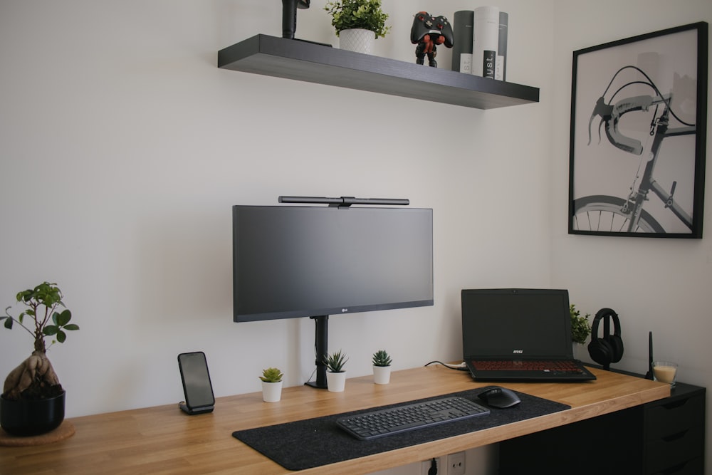 monitor per computer a schermo piatto nero su scrivania di legno marrone