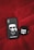 A black phone case and a black earbud case with cartoon illustrations are placed on a red textured surface. The phone case features a cartoon character with sunglasses and a white ponytail with the name 'Karl Lagerfeld' inscribed beneath. The earbud case has a cartoon cat wearing sunglasses.