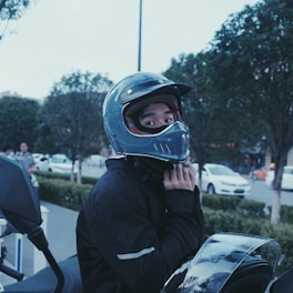 Close-up of a rider fastening a motorcycle helmet strap.