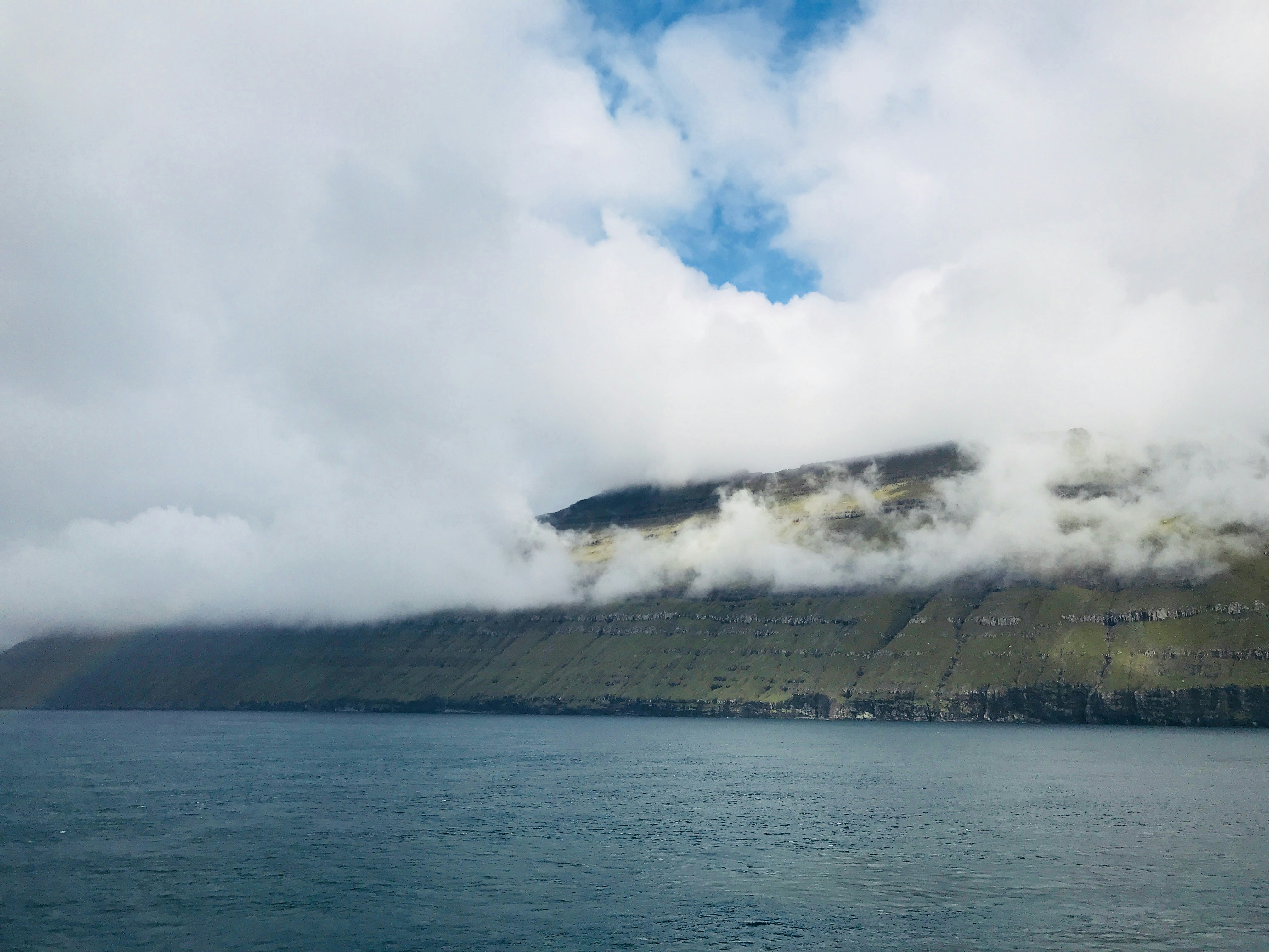 sea waves crashing on shore under white clouds during daytime