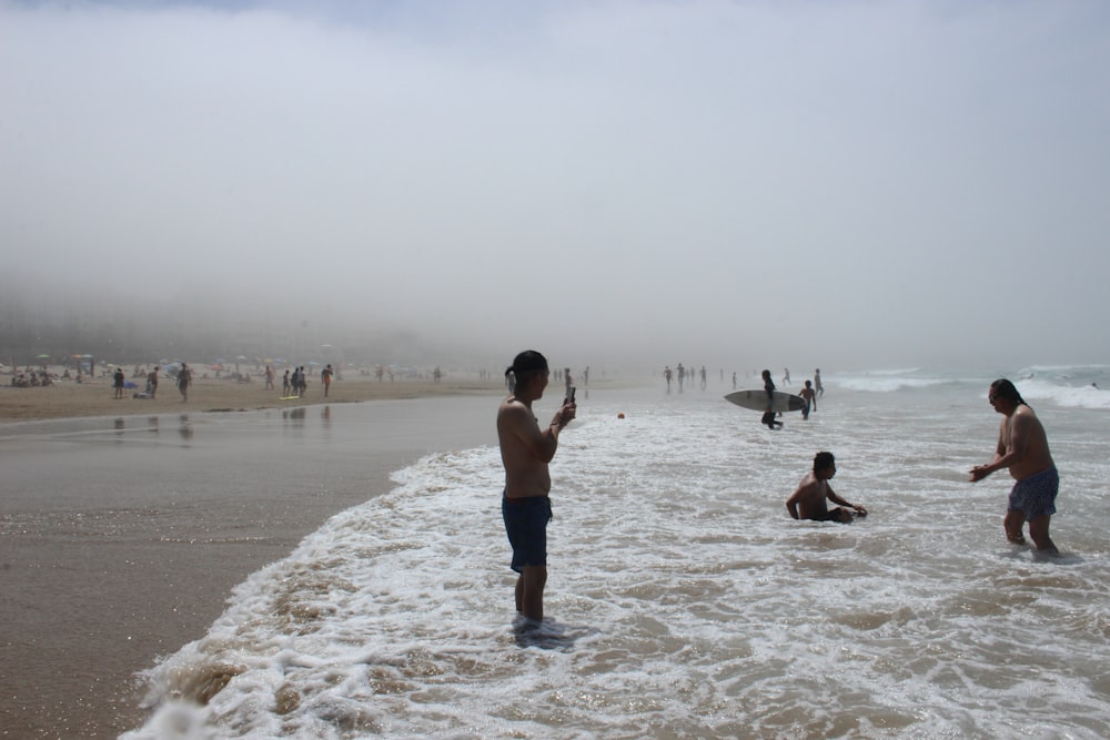 man in blue shorts standing on beach during daytime