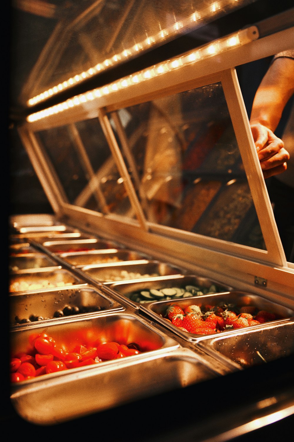 person holding stainless steel tray with red tomatoes